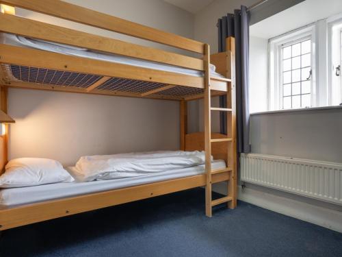 a bunk bed room with two bunk beds and a ladder at YHA Whitby in Whitby