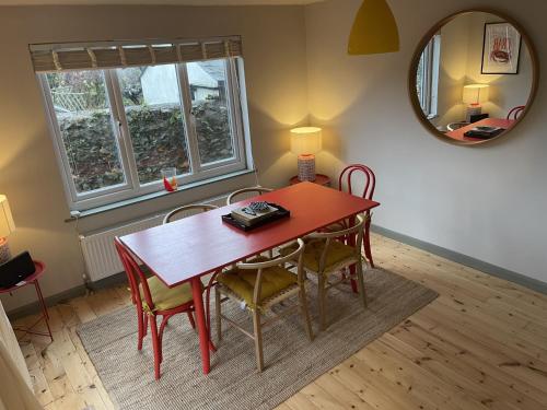 a dining room table with chairs and a mirror at Lynchway in Lyme Regis