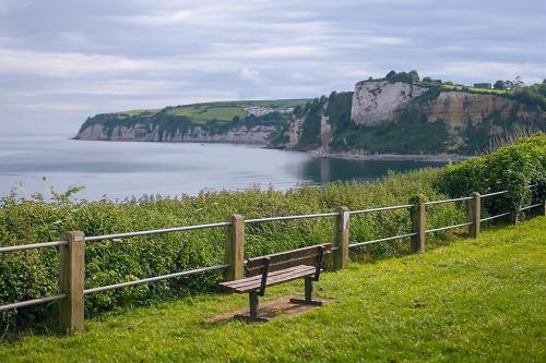 a bench sitting on top of a hill near a body of water at Sunny Side - in the Heart of Beer in Beer