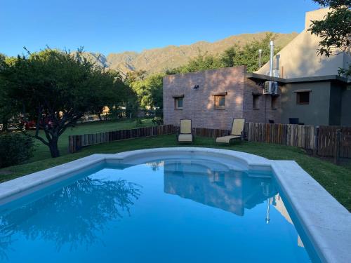 une piscine dans l'arrière-cour d'une maison dans l'établissement Shamrock House - Casa de Vacaciones en Merlo, San Luis, à Merlo