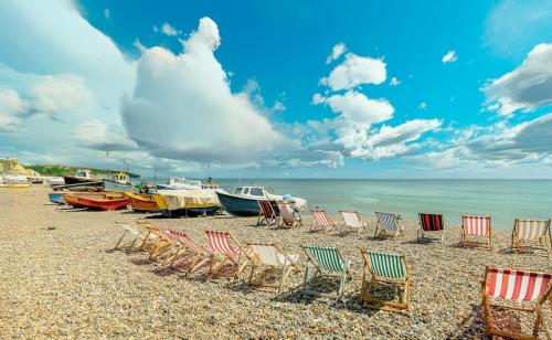 a group of chairs and boats on a beach at Sunny Side - in the Heart of Beer in Beer