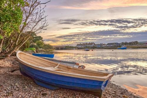 a blue boat sitting on the shore of a body of water at Sunny Side - in the Heart of Beer in Beer