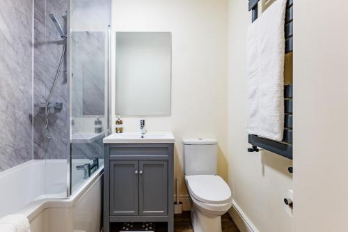 a bathroom with a toilet and a sink and a shower at Sunny Side - in the Heart of Beer in Beer