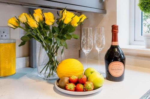 a bottle of wine and a bowl of fruit and a bottle of champagne at Sunny Side - in the Heart of Beer in Beer