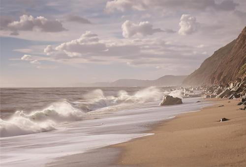 a beach with rocks and waves in the ocean at Sunny Side - in the Heart of Beer in Beer