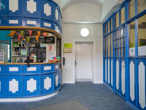 a classroom with blue and white walls and a door at YHA Whitby in Whitby