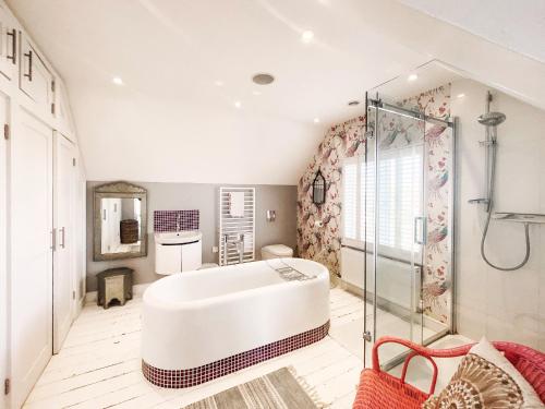 Un baño grande con bañera y ducha. en Spinneys Beachfront by The Suffolk Cottage Collection, en Thorpeness