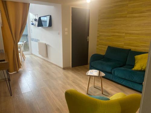 a living room with a blue couch and a table at L'Angelus d 'Etaples in Étaples