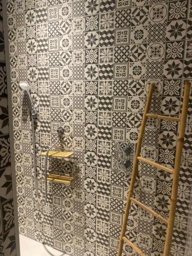 a bathroom with black and white tiles on a wall at L'Angelus d 'Etaples in Étaples