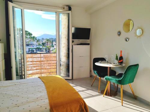 une chambre avec un lit, une table et des chaises dans l'établissement Studio Beach, à Villeneuve-Loubet