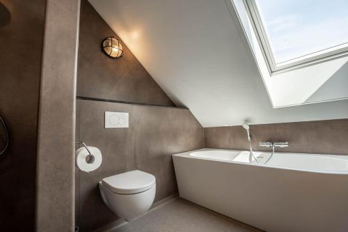 a bathroom with a sink toilet and a skylight at Appartementen De Witte Brugh in Buren