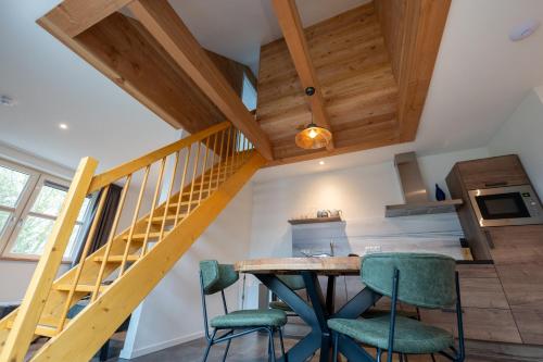a kitchen with a wooden staircase and green chairs at Appartementen De Witte Brugh in Buren