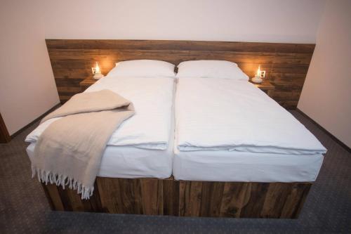 a large bed with white sheets and pillows at Wellness Hotel Zavadilka in Prostřední Bečva