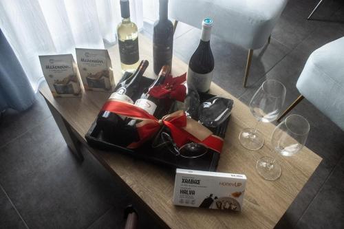 a table with wine bottles and wine glasses on it at Arfaras Home in Ixia