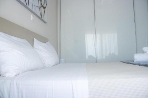a white bed with white pillows in a bedroom at Arfaras Home in Ixia