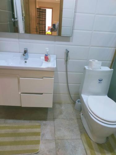 a bathroom with a white toilet and a sink at Superbe Etage Villa avec balcon, BBQ in Oulad Maʼammar
