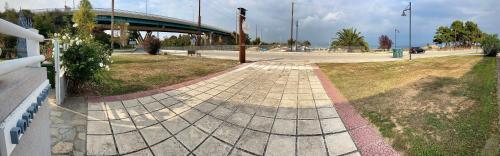 a walkway in a park with a bridge in the background at PORTO PORTES suites in Nea Potidaea