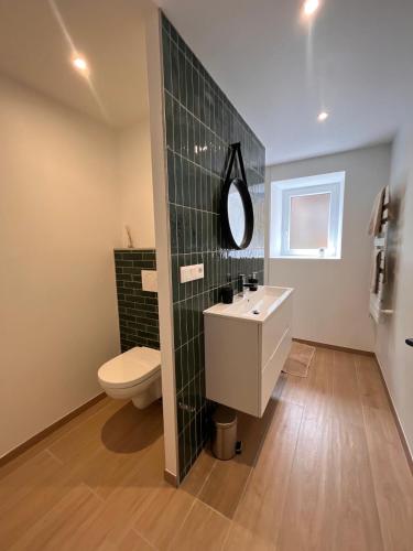une salle de bain avec toilettes, lavabo et miroir dans l'établissement Ty Ker iliz - petits commerces et plage accessibles à pied!, à Trélévern