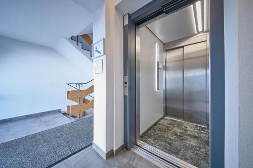 a hallway with a metal door and a stairwell at Hotel Garni Tirol in Walchsee
