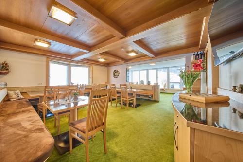 a dining room with wooden ceilings and tables and chairs at Hotel Garni Tirol in Walchsee