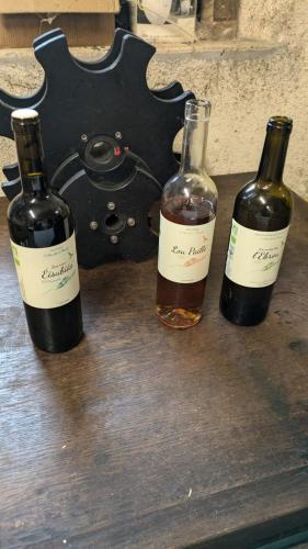 three bottles of wine sitting on a wooden table at Le Galussel Gite d'étape et de séjour in Saint-Sébastien