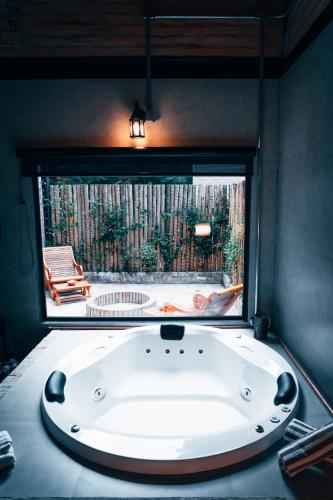 a large bath tub in a room with a window at LA PIANTA - Uma experiência na Villa de Monte Verde in Monte Verde