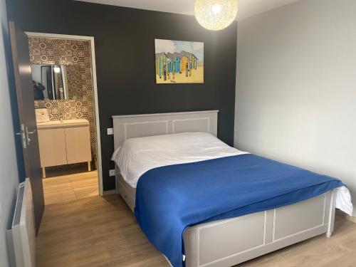a bedroom with a bed with a blue blanket at Opale d 'Etaples in Étaples
