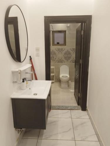a bathroom with a sink and a toilet and a mirror at Comfortable & Big Family Apartments 10Mins Drive to Al-Masjid -Nabawi - Nozol Noor 2 in Al Madinah