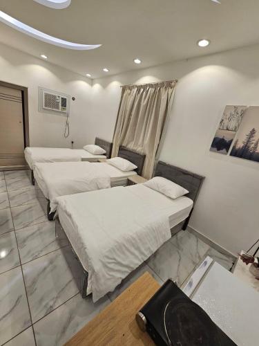 a row of beds in a room at Comfortable & Big Family Apartments 10Mins Drive to Al-Masjid -Nabawi - Nozol Noor 2 in Al Madinah
