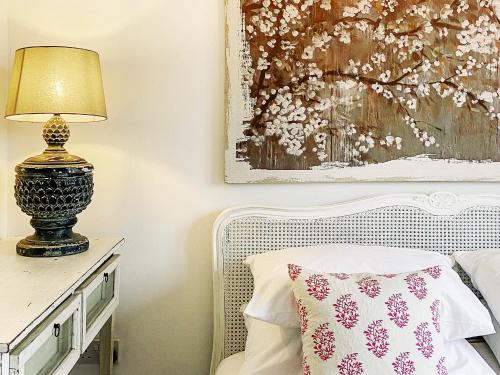 a bedroom with a bed and a lamp on a table at Spinney's Boathouse by The Suffolk Cottage Collection in Thorpeness