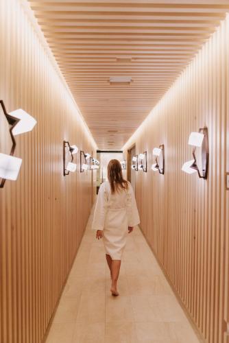 a woman walking down a hallway in a restroom at Viceroy Kopaonik Serbia in Kopaonik