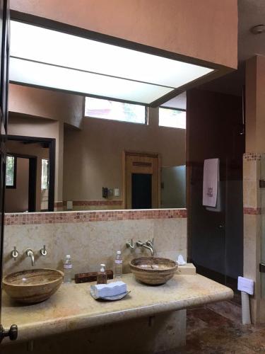 a bathroom with two sinks and a large mirror at Hotel & Spa Hacienda de Cortés in Cuernavaca