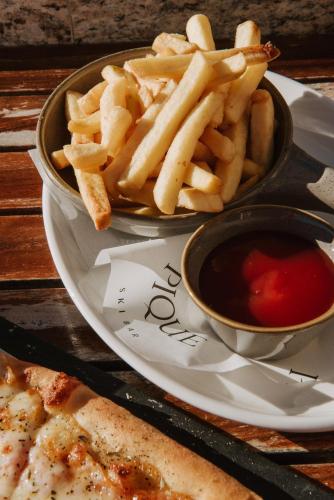 a plate of french fries and a bowl of ketchup at Viceroy Kopaonik Serbia in Kopaonik