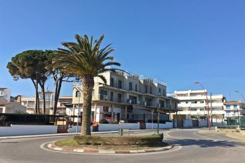 a street with palm trees in front of a building at Duplex Univers - Frente al mar in L'Escala