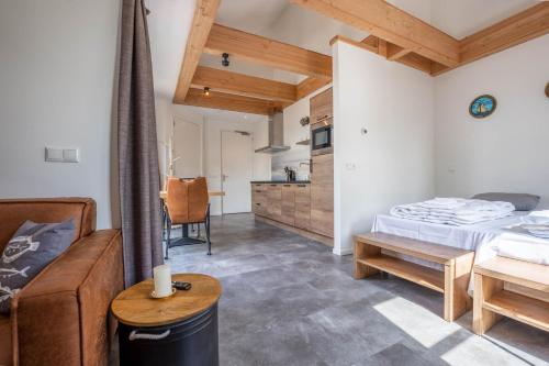 a room with a bed and a couch and a table at Appartementen De Witte Brugh in Buren