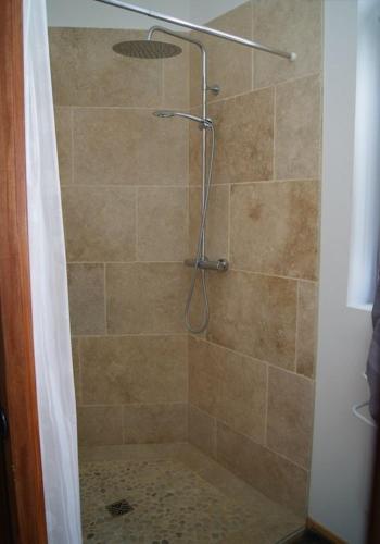 une salle de bain avec une douche avec un rideau de douche dans l'établissement Le Pentagone, à Bruniquel