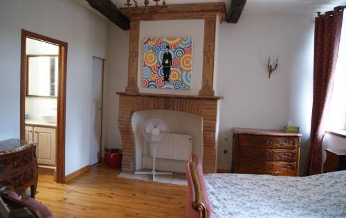 - une chambre dotée d'une cheminée et d'une peinture murale dans l'établissement Le Pentagone, à Bruniquel