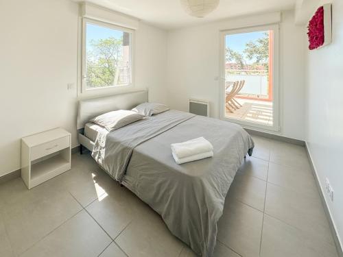 une chambre blanche avec un lit et deux fenêtres dans l'établissement Clos des Cèdres - terrasse et 2 parkings gratuits, à Montpellier