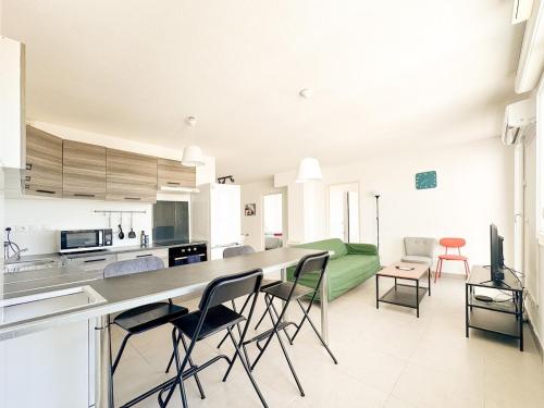 une cuisine et un salon avec un comptoir et des chaises dans l'établissement Clos des Cèdres - terrasse et 2 parkings gratuits, à Montpellier