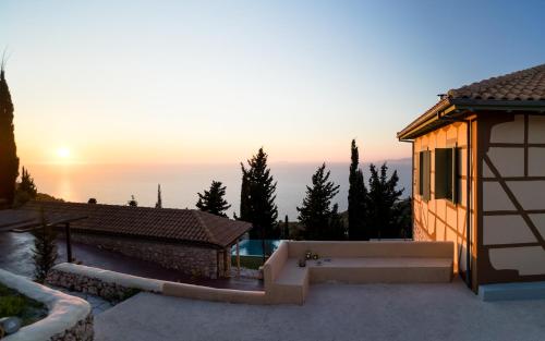 a view of a house with the sunset in the background at melivaro villa in Tsoukaladhes