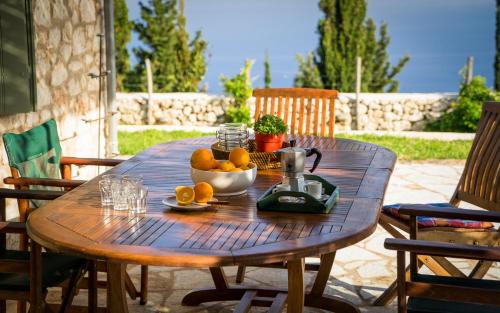 a wooden table with a bowl of oranges on it at melivaro villa in Tsoukaladhes