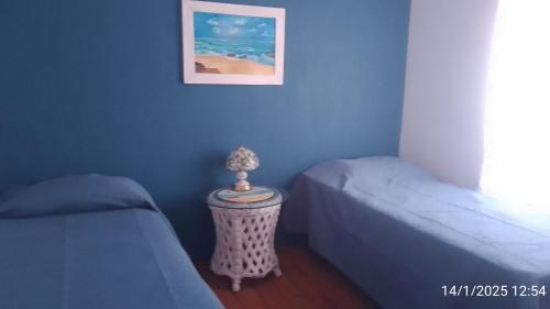 a room with two beds and a table with a picture at Rincón de Luz in José Ignacio