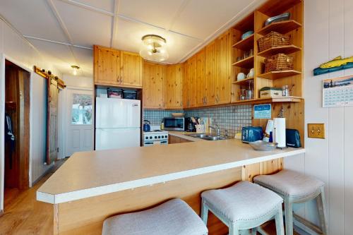 a kitchen with wooden cabinets and a counter with stools at Eastpoint Escape in Langley