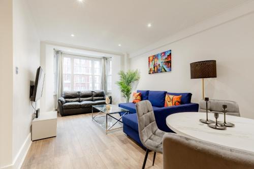 a living room with a blue couch and a table at Central Apartments near Marble Arch in London