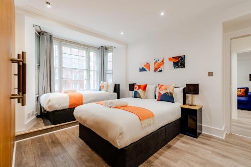 a bedroom with two beds and a window at Central Apartments near Marble Arch in London