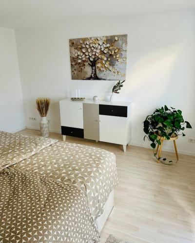 a bedroom with two beds and a painting on the wall at Golden Hour Apartment in Kaiserslautern