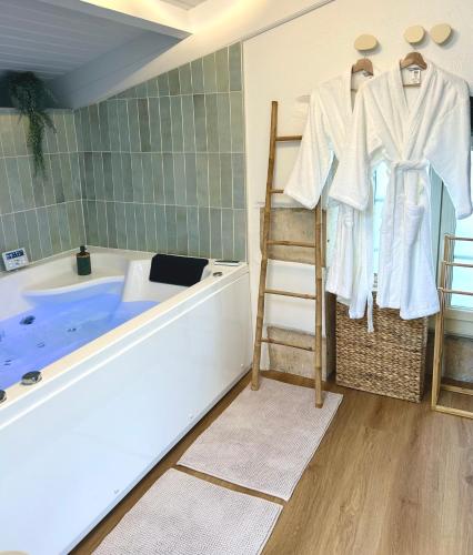 La salle de bains est pourvue d'une baignoire, d'une échelle et d'une chaise. dans l'établissement L 'Écrin - Balnéo & Cinéroom, à Poitiers