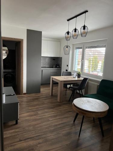 a living room with a table and a kitchen at IQ Apartments in Prešov