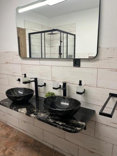a bathroom with two sinks and a mirror at IQ Apartments in Prešov
