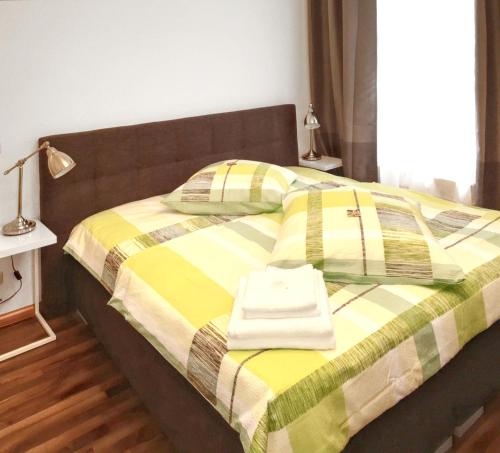 エアフルトにあるCozy apartment in the heart of Erfurt 30 m² city viewの黄色と緑の毛布と枕が置かれたベッド
